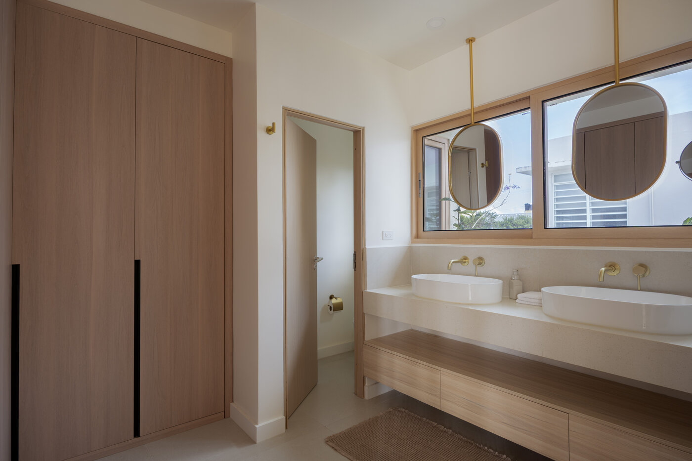 Baño principal con mueble a medida, sanitarios y ventanal de aluminio